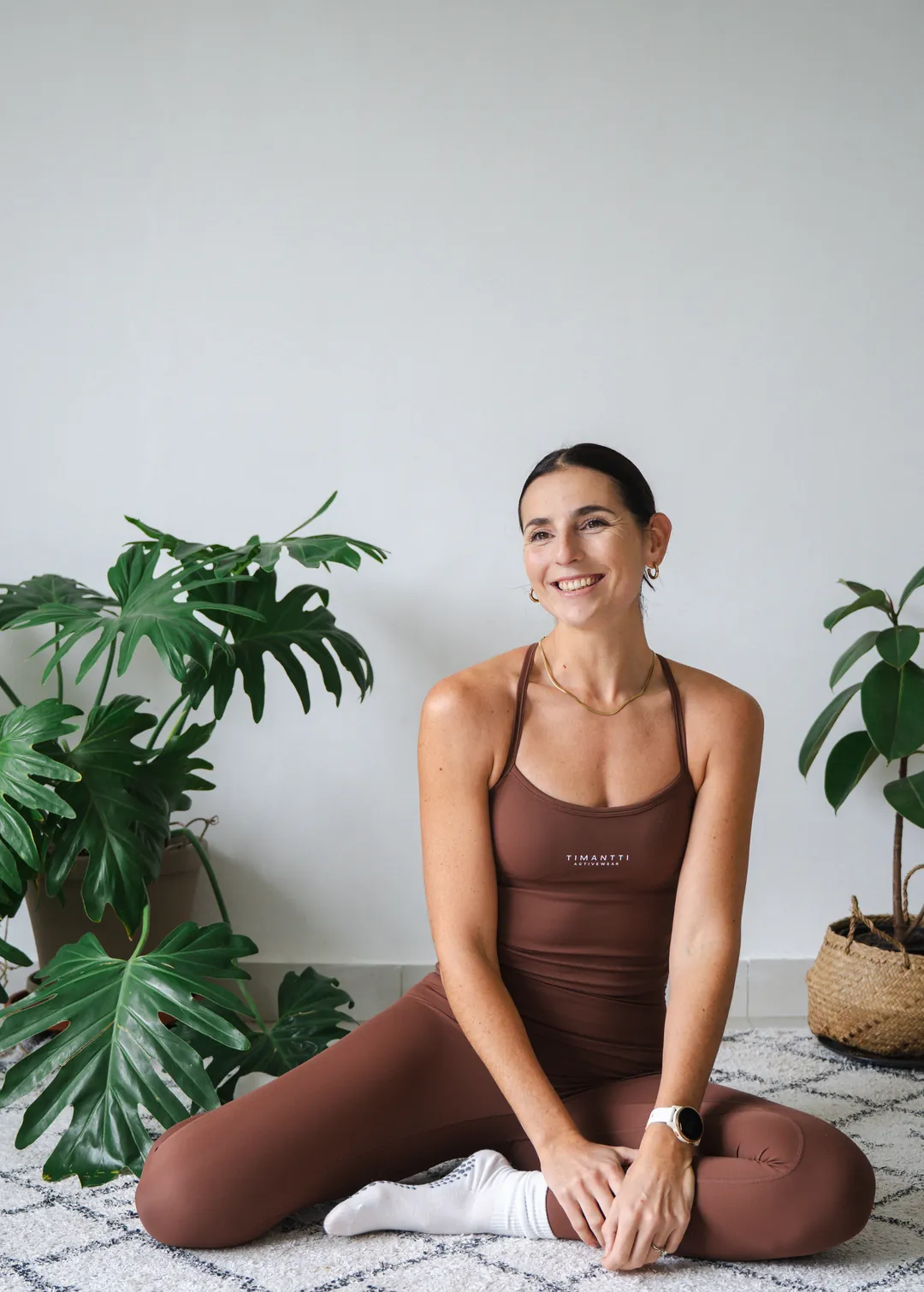 Carla sitting cross-legged on the floor, smiling